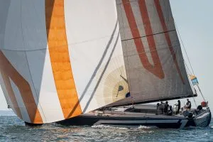 barca a vela per aziende – barca a vela con vele bianche e arancioni in navigazione